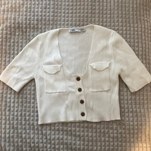 Vit ribbad t-shirts med knappt  - Säljer denna T-shirt för 100 kr plus frakt, använt den minst 3 gånger, den är varken sönder eller förstörd på något sätt.  Det är storlek S som var den minsta storleken alltså passar den xs också (jag själv är xs) 