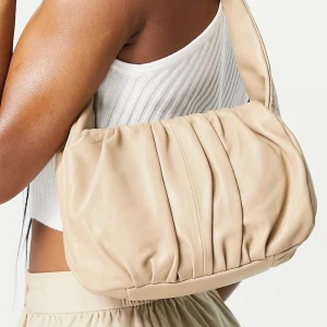 Beige axelväska från asos  - Beige axelväska av läder, från asos design. I fint skick, endast använd en gång. Skriv gärna för frågor<3 skickas med postnord spårbar 