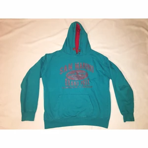 Hoodie (grön-aqua) - Säljer en häftig, retro hoodie i en blå/grön/aqua-ish färg. Hoodien har ett rött tryck och är röd i luvan. Tröjan är använd men är i ett bra skick. Den är i storlek M (unisex) och passar mig bra (är en S/M). (Sänker tröjans pris då jag såg att kanten på hoodiens ficka gått upp lite). Meddela mig vid fler frågor!😊