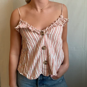 Randigt linne! - Rostrött/vitt randigt linne med volang och turtoise knappar från Zara. Är 170 och har oftast S/36. Använd några gånger men fortfarande i väldigt bra skick! 