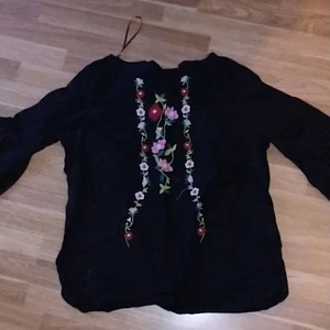 Svart blus med blommor på - En blus med blommor, XL