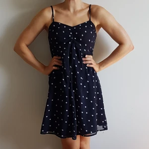 Marinblå klänning med vita prickar - Marinblå klänning med vita prickar från Vero Moda, storlek S. Smala, justerbara axelband. Kreppat chiffongliknande tyg, samt smockat i ryggen. 🙂👗