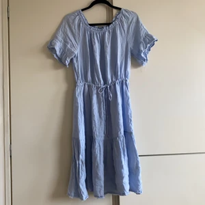 Ljusblå sommarklänning med volang - Ljusblå volangklänning från Part Two med snörning i midjan, knälång modell. Stor i storleken, passar en 38/40 eller en 36:a med loose fit. 