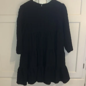 Klänning från Zara storlek S - Svart klänning med 3/4 ärmar. Bredare passform och kjolen har sydda paneler. Vågigt tyg. Endast använd en kväll.