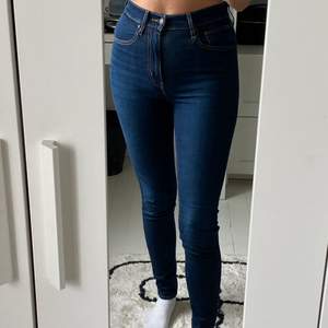 Tighta högmidjade Levi’s jeans i mörkblått i storlek 27. Använda en eller två gånger. Ganska långa. Köpta för 1299 och säljer för 900.