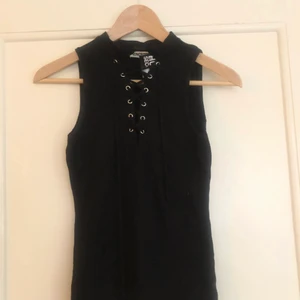 Topp med snörning - Svart topp i stretchigt material från humana med snörning. Står ej storlek men skulle beskriva den som en small, ev liten medium.