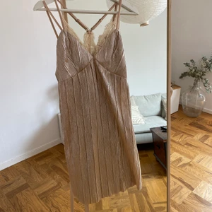 Guldig klänning från NAKD - Så fin klänning i strl XS från ett varumärke som heter J.O.A inköpt på Nakd säljes då den ej kommer till användning!