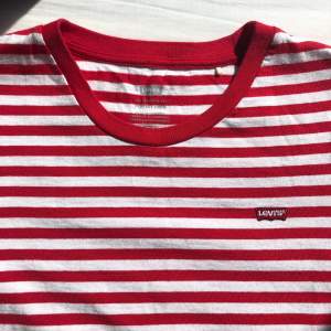 Röd och vit randig Levis t-shirt med liten Levis patch på bröstet, använd ett par gånger, bra skick, inga skador. Storlek S