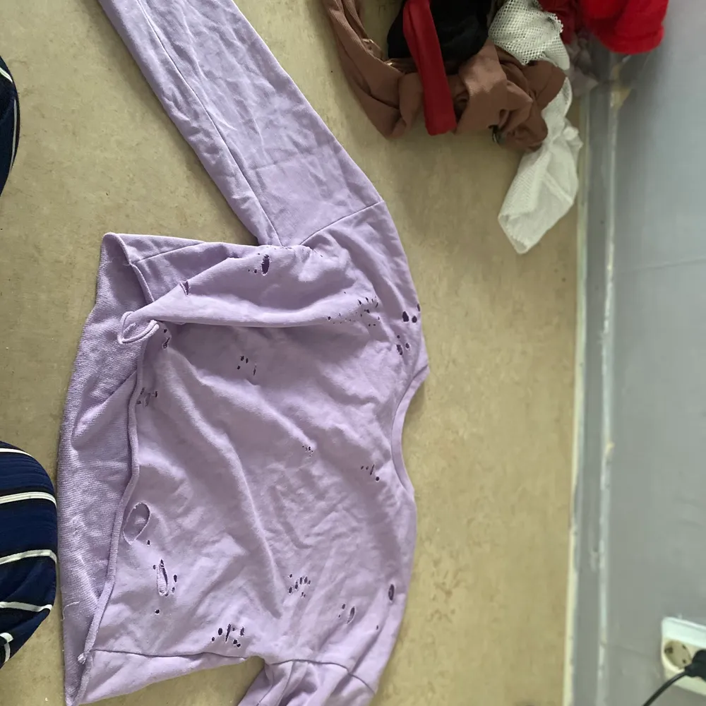 En lila tröja som har massa hål i sig, det är en Nah tröja och den sitter löst. Tröjor & Koftor.