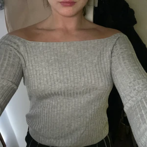 Grå off-shoulder top - Superskön grå off shoulder top i mjukt skönt ribbstickat material! Säljes för används inte, sitter som S/M men är storlek M. Superfin och återkommande mode just nu !