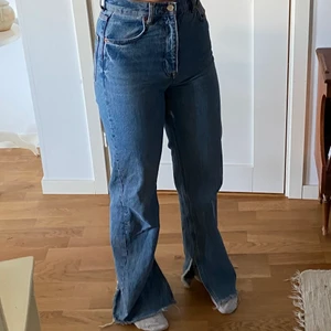 Zara Jeans - Blåa högmidjade jeans med slits från Zara i storlek 34! Använt ett fåtal gånger, fint skick! Lite långa för mig som är 1,65. Finns inte längre att köpa på Zara, nypris: 399kr. Köparen står för frakt på 66kr. Om du vill ha fler bilder på modellen eller längd, säg till😁