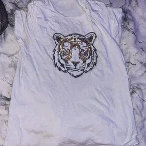 Vit tröja med lejon tryck i glitter - Basis vit tröja köpt från loppis men inte använd och helt i nyskick 