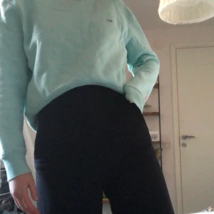 Sweatshirt från Tommy Jeans - Säljer denna turkosa sweatshirten från Tommy jeans. Säljer pågrund av att jag inte använder den, är i nyskick. Sweatshirten är kroppad i midjan. Står att den är i stolek M men skulle mer säga S. Skriv till mig för frågor.