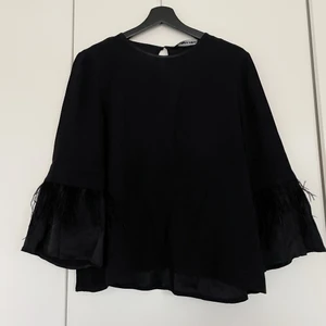 Svart blus med fjädrar - Storlek S
