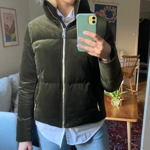 Grön dunjacka i sammet - Varm dunjacka i grön sammet! Jättefint skick från Tommy Hilfiger. Något liten i storleken, passar persom med storlek S-M.
