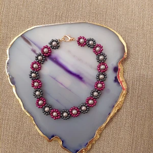 Pärlarmband  - Pärlarmband i form av blommor. 20cm långt.