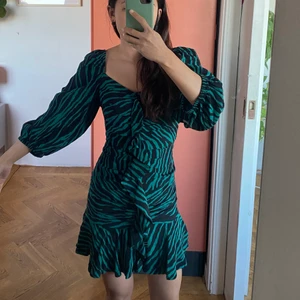 Djurmönstrad mini klänning - Jättefin mini klänning med tigermönstrad i grön och svart och med puffärmar från Zara. Aldrig använd! Den är ny!