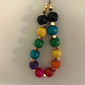 Regnbågs armband! :D - Armband med olika färger träpärlor, guldiga pärlor och elastisk tråd! Cirka 15 cm! 