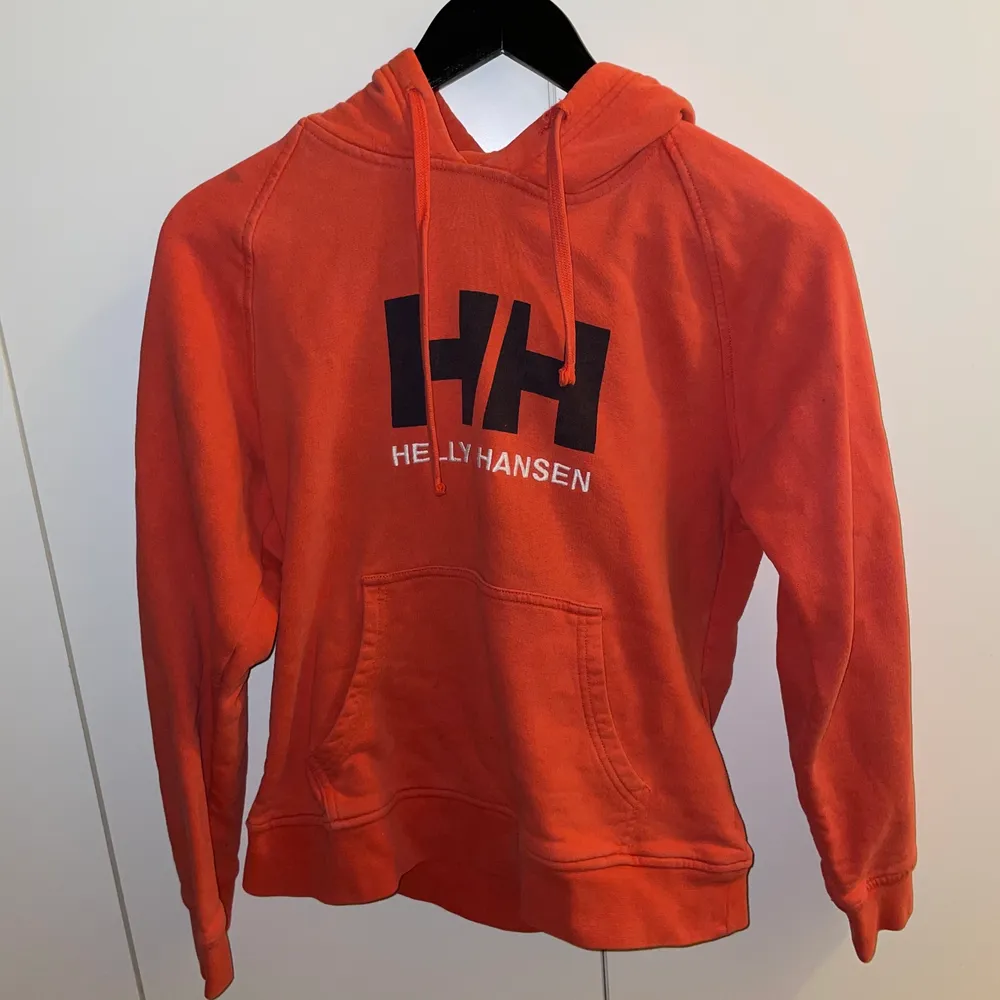 Röd/orange Helly Hansen Hoodie i storlek XS, passar även S. Skön och lagom tajt på kroppen!. Tröjor & Koftor.