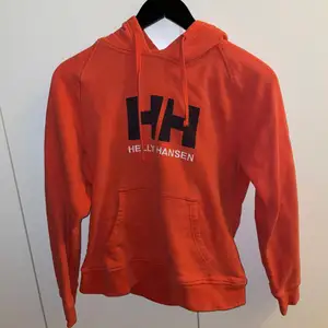 Röd/orange Helly Hansen Hoodie i storlek XS, passar även S. Skön och lagom tajt på kroppen!