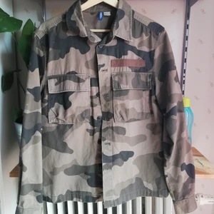 Camo jacka - Tygjacka i camo med lila broderad text på ryggen. Jättefint skick! 