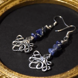 Örhängen bläckfisk  - Örhängen med silvriga bläckfiskar och äkta lapiz lazuli. Krokarna är nickelfria. 