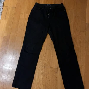 Jeans ASOS - Svarta jeans i 90-talsstil med raka ben och medelhög midja. Väldigt snygga jeans med snygga detaljer. Använd ett fåtal gånger men är i bra skick. Storleken är 28/32 och är i perfekt längd för mig som är 169 cm. Säljer pga av för små i midjan. Nypris 319kr 