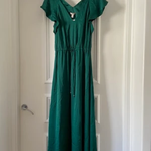 Grön långklänning - Söker en oanvänd grön långklänning i satin material. Storlek 38. 200kr