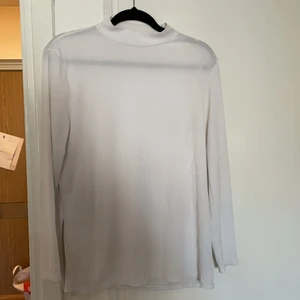 Vit polo med slits  - En vit polo tröja med slits i sidan. 