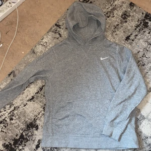 En Ljusgrå Nike Hoodie  - En ljusgrå Nike Hoodie som är köpt här från plick, den är även i ett bra skick. Säljer den för att den var lite för kort för mig i ärmarna ☹️ 