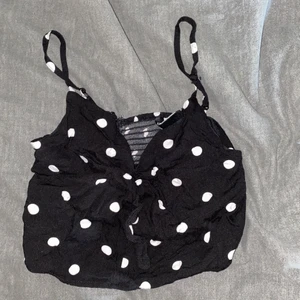 Prickig top - Super söt prickig topp. Storlek 36 men jag som har 38 får plats i den. Perfekt till sommaren. Har en rosett på framsidan som man kan knyta.