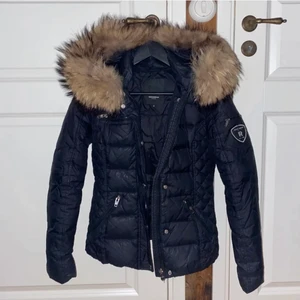 Rock and blue jacka  - Säljer min rock and blue jacka i strl 32 då den blivit för liten. Har använt den en vinter så den är i gott skick bortsett från att den tappat några bokstäver på märket. (Se bild 2). Pälskragen är äkta päls. Köpte den för 3700kr på Miinto och säljer den för 1200kr. Pris kan diskuteras. Köparen står för frakten. 