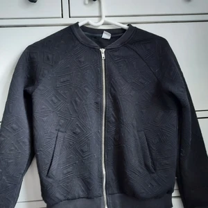 Lindex, kofta med dragkedja  - Barn, storlek 146/152 10-12 years, svart med triangelmönster 