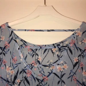 Blommig blus - Blommig blus i blå, vit och rosa. Fin rygg som är lite öppen, se bild 1! Kortare vida ärmar! Tunn och luftig och perfekt till sommaren🥰 säljer för 50kr, du står för frakten🥰