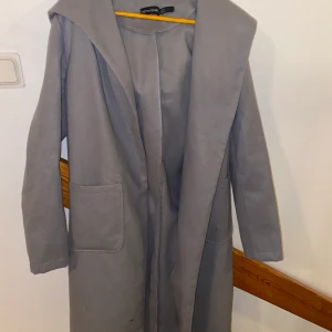 Kappa - Grå långkappa i storlek 38! Använd fåtal gånger. Har 2 rymliga fickor och stor luva. Använd under vår och höst.