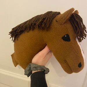 Handsydd käpphäst / hobbyhorse - (Undanber onödiga kommentarer om priset och om annat, Det är satt av en anledning❤️) Käpphäst till salu, sydd i brunt / lite fux färgat fleecetyg. Stängd mun och helt rak. Allt på hästen är sytt för hand🥰 Ungefär lika stor som ett A4 papper (bild 2). Vid seriöst intresse så går det att få fler bilder privat😊 Betalning sker endast via swish. Frakten är inräknad i priset, och är även spårbar. Ingår: Hästen, brev. Ingår ej: vadd, käpp. 