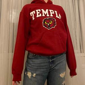 Snygg, röd vintage hoodie med texten ”TEMPLE”. Jätte bra skick! Storlek herr S och modellen på bilden är 163 och dam XS-S. Tar bud från 199kr + frakt! 