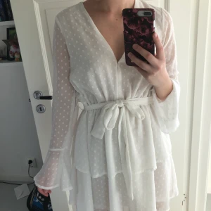 Vit klänning - Säljer denna fina klänning som är perfekt till skolavslutning eller student från Madlady. Det går att sy in v-ringningen så att den inte är lika djup. Använd tre gånger. Man kan även ta bort snöret i ryggen. 