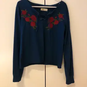 Superfin tröja med broderade blommor och knyt framtill.💕 den är superskön men kommer ej till användning längre. Den är ifrån Hollister.