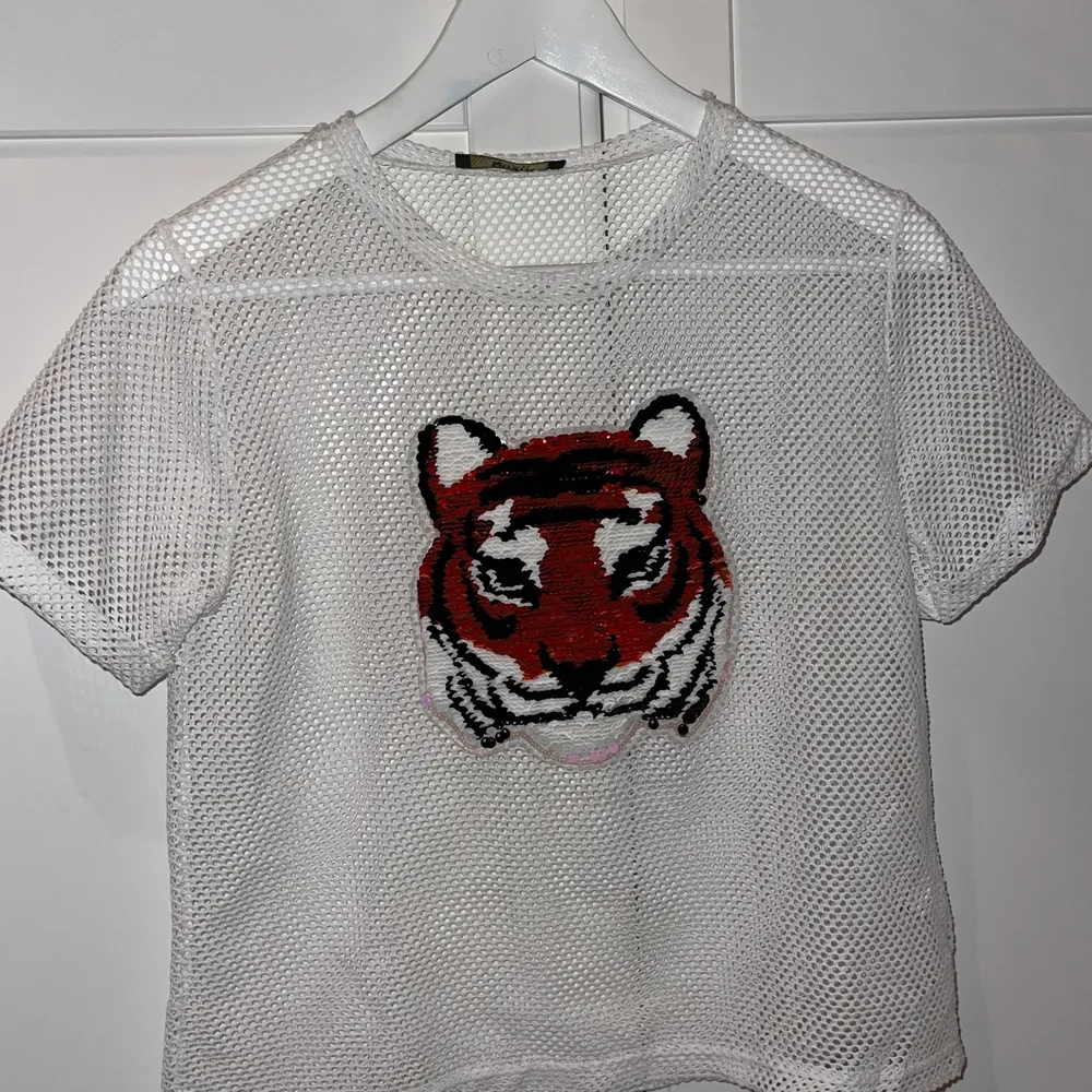 Säljer min T-shirt som har en tiger på med paljetter som man kan dra ner och upp för att ändra färg, jättefin under en långärmad tröja eller vad som helst, använt 1 gång . T-shirts.