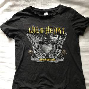 En svart tröja med ett tryck på. Citat: Wild Heart Fearless Mind, World Tour 1998. Hade användt den om den passade i storleken men tyvärr för liten. Inte använd mycket men lite urtvättad så nytt pris!✨