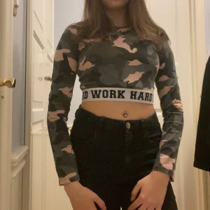 Tröja - Croppad långarmad tröja med millitärmönster och resår rund midjan. Säljs då den aldrig kommer till användning. Köparen står för frakten.