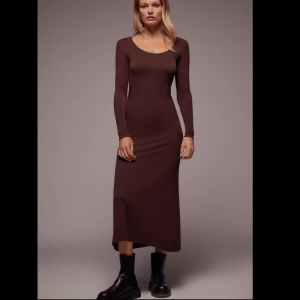 Klänning - Stickad lång klänning i färgen brun som nu är slutsåld. Oanvänd med prislappar kvar, ord pris 360kr. Spårbar frakt tillkommer på 66kr