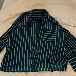 Grön skjorta från monki i oversize stil - Jättesöt randig skjorta från monki som knappt är använd, helt i nyskick! Lite oversize beroende på din storlek, men superskön att slänga över ett linne eller så.