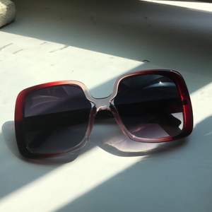 Stora fyrkantiga solglasögon som skiftar i rött rosa och genomskinligt