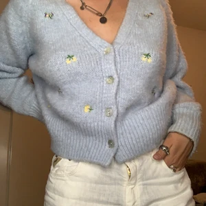 Blommig stickad kofta - Mysig kofta med broderade blommor, är ganska stor men är en Medium