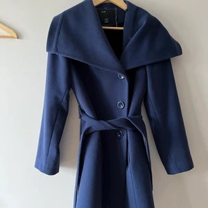 Marinblå kappa - Säljer denna superfina varma kappan från ICON pga att den inte kommer till användning. Kappan är i storlek 42 och sitter bekvämt oversized på mig som egentligen har 34. Denna kappan passar bra till höst och vinter eftersom insidan är fodrad med svart, mjukt tyg för att hålla värmen. Väldigt sparsamt använd och i väldigt bra skick. Säljer för 400 kr+Eventuell frakt. Kan mötas i Göteborg eller skickas💞