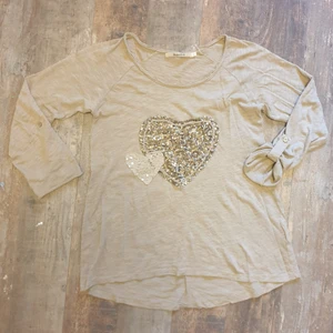 Beige offshoulder tröja hjärta - Såå fin passform, går att dra över axeln lite och knäppa upp vid armarna, står stlk XS men skulle passa större storlekar. Älskar den men används inte tillräckligt </3  Vill bli av med den! Superbra skick, helt felfri ✨️