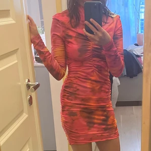 Klännig - Acidmönstrad, rufflad klänning med halvpolo-krage. Knälång men går att ha både kort eller längre pga stretchig. Så fin! Använd 1 gång