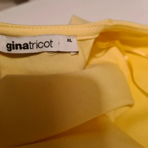 Klänning - Gul klänning med öppen rygg och volanger runt, aldrig använd 